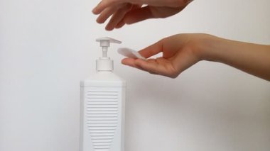 Dişi eller, virüslerin ve bakterilerin yüzeylerinin dezenfekte edilmesi için pamuk bloknota antiseptik döker. Dezenfekte spreyi, yüzeydeki bakteri ve virüslerin% 99.9 'unu güvenli bir şekilde öldürüyor..