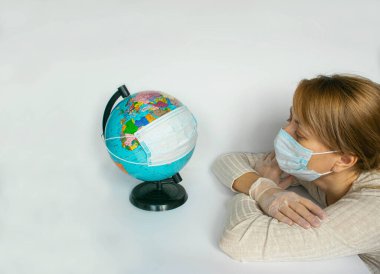 Korunaklı maskeler içindeki kadın ve Dünya küresi, tüm gezegendeki insanların Coronavirus salgını ve salgını nedeniyle karantinaya alındığının bir simgesidir. Boşluğu, afişi ya da şablonu kopyala.