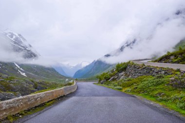 Dağlarda sis ve alçak bulutlarla kaplı güzel dar bir yol. Ulusal turizm yolu 258 Stryn - Grotu, dağları aşan yol. Norveç 'e arabayla yolculuk.