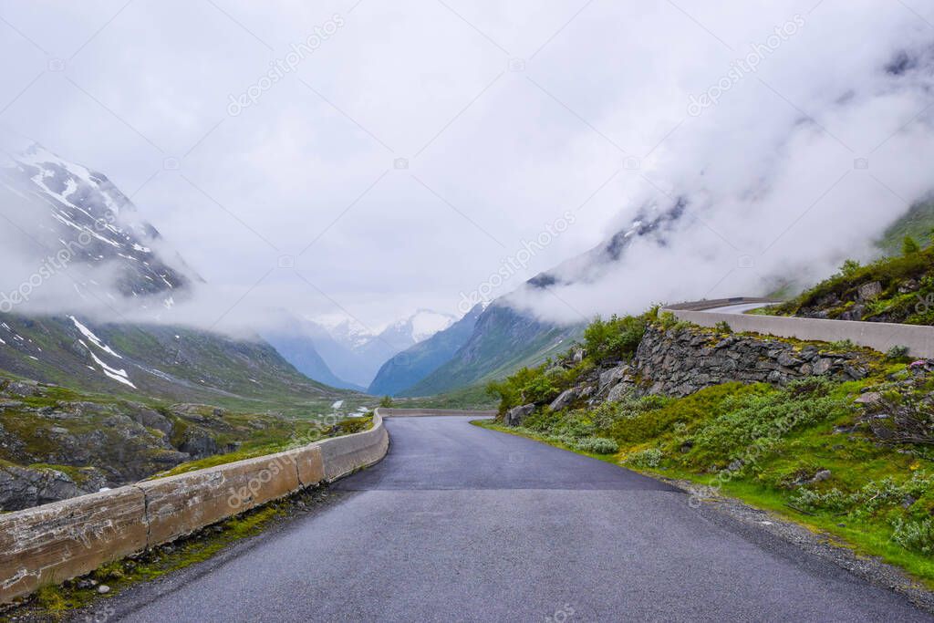 Beautiful narrow road in the mountains covered by fog and low clouds. National tourist road 258 Stryn - Grotu, that running across the mountains. Trip by car to Norway.