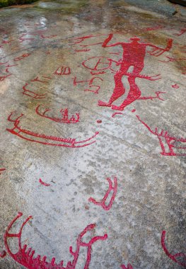 Bronz Çağı 'ndan kalma ve bir zamanlar UNESCO' nun Dünya Mirası Alanı olan fiyort kıyılarında bulunan kaya oymaları. Bazıları turistler için kırmızıya boyandı. Tanum, İsveç.