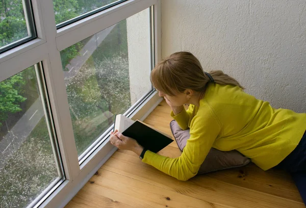Beyaz Bir Kadın Karantina Döneminde Panoramik Pencerenin Yanında Yatarak Kitap — Stok fotoğraf