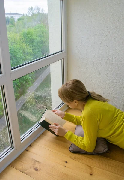 Beyaz Bir Kadın Karantina Döneminde Panoramik Pencerenin Yanında Yatarak Kitap — Stok fotoğraf
