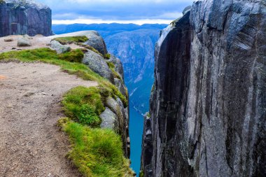 Lysefjorden 'ın 984 metre yüksekliğindeki iki uçurum arasındaki yarıktan görünüşü, ünlü Kjeragbolten' in dünyanın en tehlikeli taşı yakınlarda sıkışıp kaldığı yer. Kjerag Dağı, Rogaland Bölgesi, Norveç.