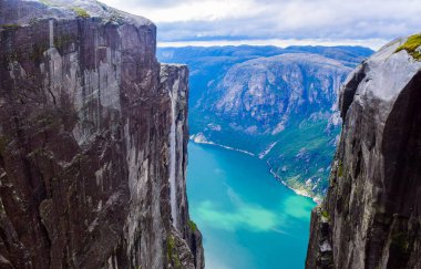 Lysefjorden 'ın 984 metre yüksekliğindeki iki uçurum arasındaki yarıktan görünüşü, ünlü Kjeragbolten' in dünyanın en tehlikeli taşı yakınlarda sıkışıp kaldığı yer. Kjerag Dağı, Rogaland Bölgesi, Norveç.