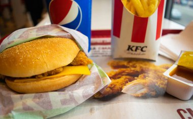 Kiev, Ukrayna - 8 Mart 2020: Popüler bir fast food restoranı olan KFC 'de yiyecek ve içecek. Kentucky Fried Chicken olarak bilinen popüler fast food zinciri. Patates kızartması, Pepsi ve köri soslu burger..