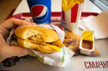Kiev, Ukrayna - 8 Mart 2020: Popüler bir fast food restoranı olan KFC 'de yiyecek ve içecek. Kentucky Fried Chicken olarak bilinen popüler fast food zinciri. Patates kızartması, Pepsi ve köri soslu burger..
