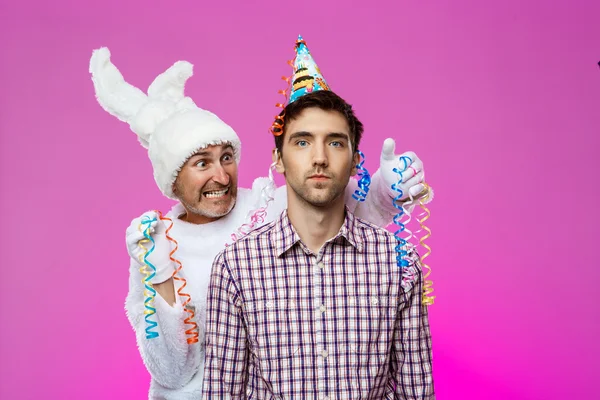 Drunk man and rabbit at birthday party over purple background.