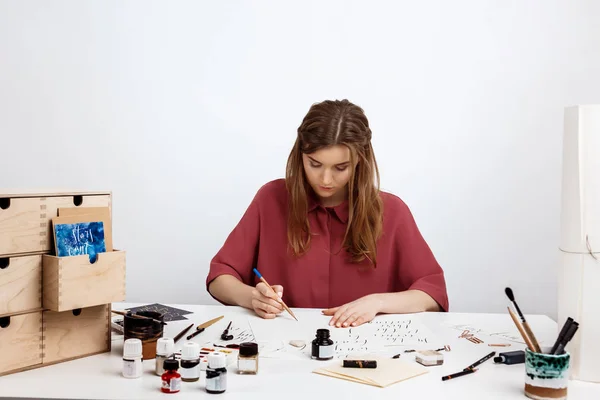 Girl writing calligraphy on postcards. Art design.