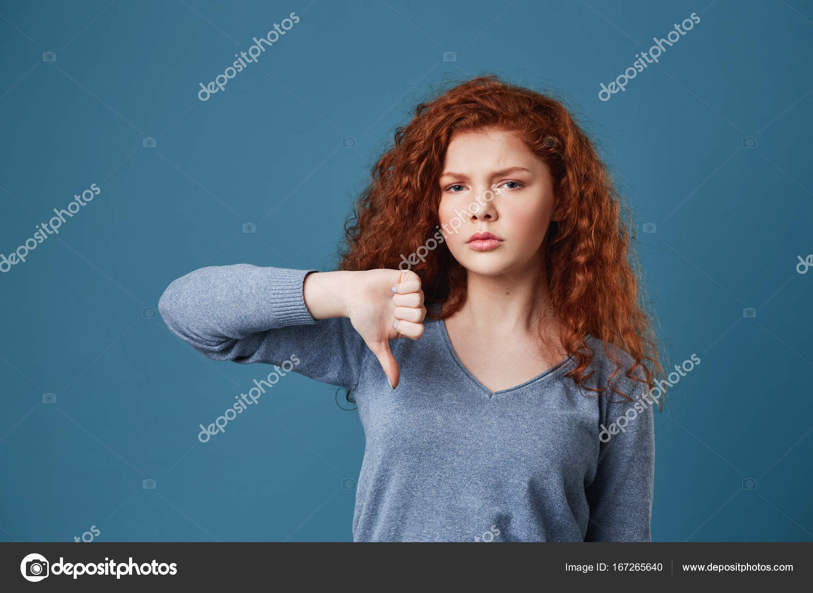 Unhappy Good Looking Girl With Red Curly Hair And Freckles Looking