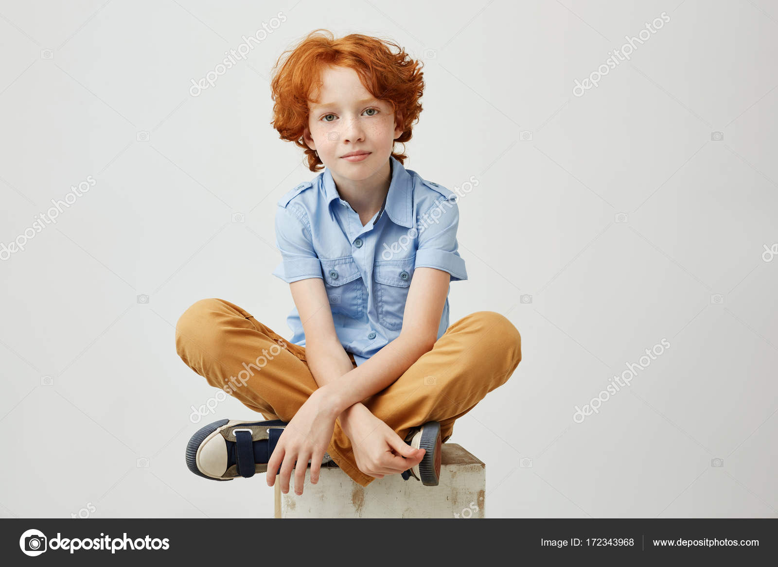 Little Funny Boy With Orange Hair And Freckles Sitting On Wooden