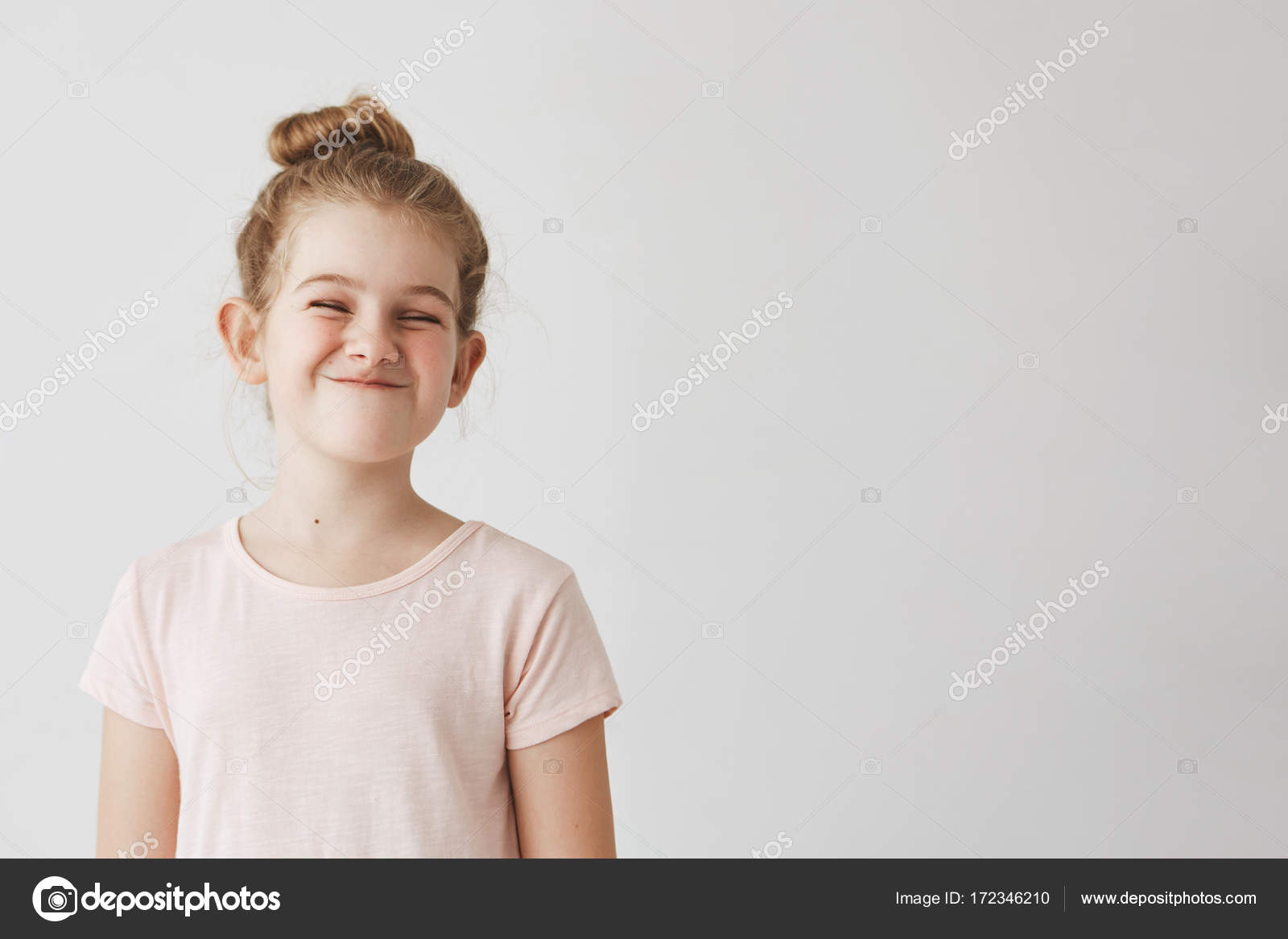 Happy Little Girl With Blond Long Hair In Bun Hairstyle