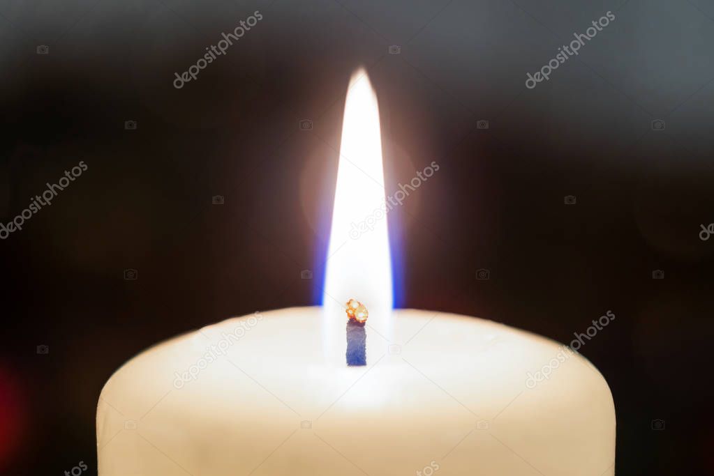 Closeup of a white burning candle