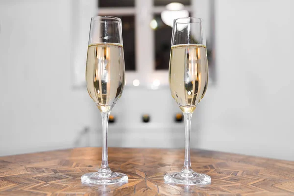 Two glasses filled with champagne on a antique table — Stock Photo, Image