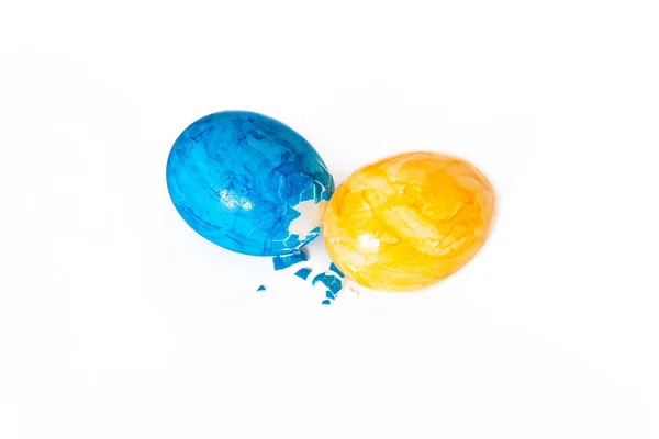 Eieren pikken met blauwe en gele paaseieren en witte achtergrond — Stockfoto