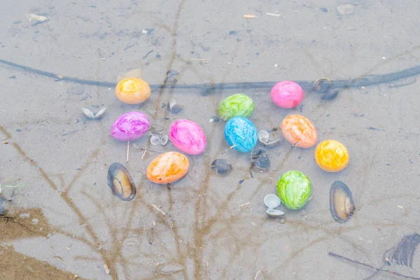 Coloridos huevos de Pascua en una orilla del río —  Fotos de Stock