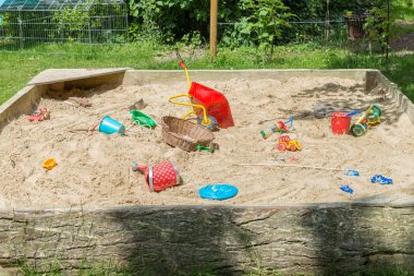 Bir bahçe içinde birçok toys ile büyük kum
