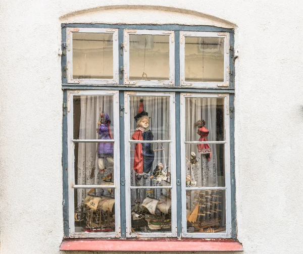 Window with old string puppets and model ships — Stock Photo, Image