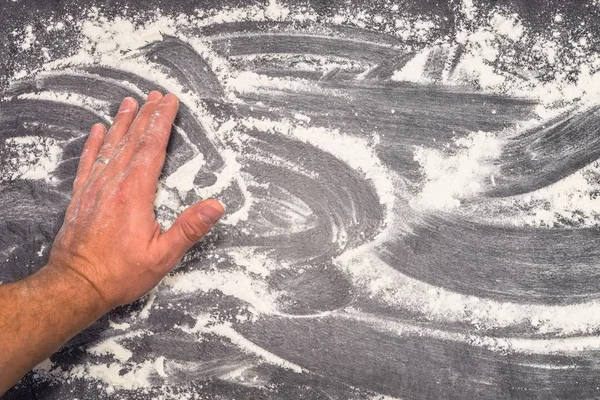 Harina de trigo en la superficie de trabajo gris limpiada con la mano masculina — Foto de Stock