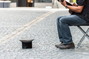 Top hat on cobblestone with street musician clipart