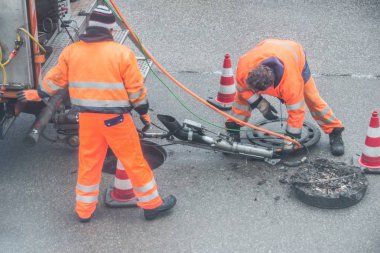 Kanal işleri için Alman sözleriyle uyar ile kanalizasyon kanalında sokak works oturum