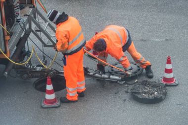 Kanal işleri için Alman sözleriyle uyar ile kanalizasyon kanalında sokak works oturum