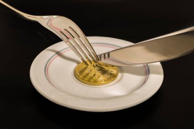 Altın sikke bitcoin bıçak ve siyah arka plan üzerine izole çatal ile plaka üzerinde