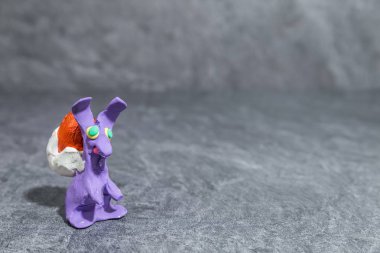 Paskalya tavşanı mor oyun hamuru gri arka plan önünde yapılmış