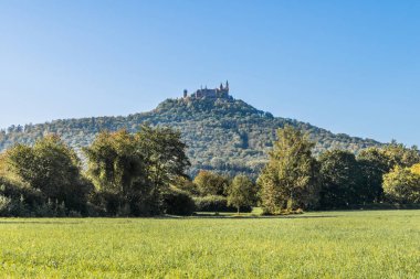 Bisingen 'deki Hohenzollern Kalesi mavi gökyüzü ve yeşil çayır, Baden-Wrttemberg, Almanya