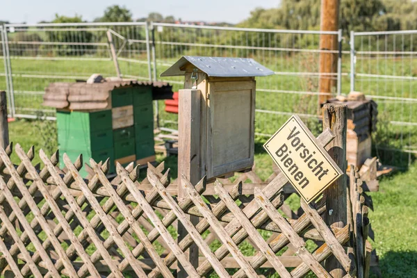 Beehive and insect hotel with a sign in German language - Caution bees, Germany