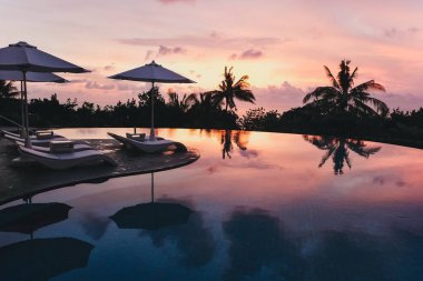 Güzel günbatımı Bali Adası. Yüzme Havuzu gün batımında. Bali dili günbatımı.