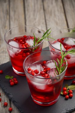 Kızılcık ve biberiye ahşap arka plan üzerinde serinletici içecek