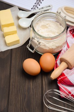 Pişirme - maddeler tereyağı, yumurta ve koyu ahşap arka plan üzerinde un