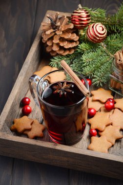 Noel mulled şarap. Tatil kavramı çam dalları, Gingerbread çerezleri ve koyu ahşap tepsi Cranberries ile dekore edilmiş.  