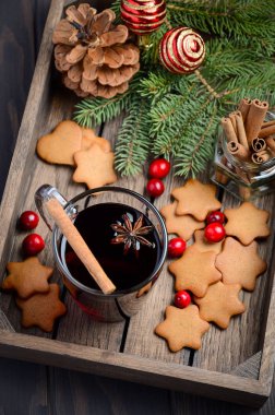 Noel mulled şarap. Tatil kavramı çam dalları, Gingerbread çerezleri ve koyu ahşap tepsi Cranberries ile dekore edilmiş.  