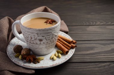 Hint masala chai çay. Rustik ahşap masa üzerinde süt ile baharatlı çay.