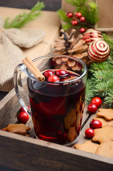 Christmas mulled wine. Holiday concept decorated with Fir branches, Gingerbread Cookies and Cranberries on dark wooden tray.