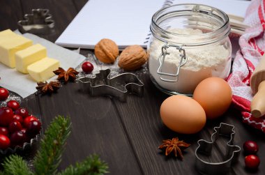 Malzemeler - çerez kesiciler, baharat, tereyağı, yumurta ve un koyu ahşap arka plan üzerinde pişirme Noel