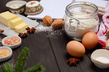 Noel malzemeler kek kalıpları, baharat, tereyağı, yumurta ve un koyu ahşap arka plan üzerinde pişirme