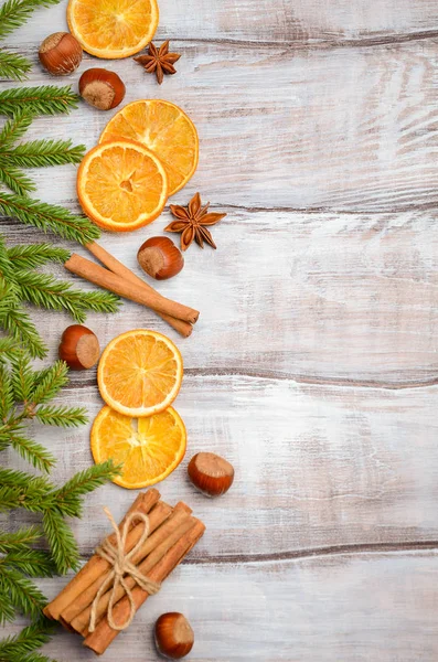 Christmas background with fir branches, spices, nuts and slices of dried orange. — Stock Photo, Image