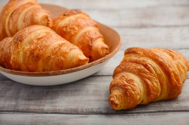 Rustik ahşap zemin üzerine taze kruvasanlar.