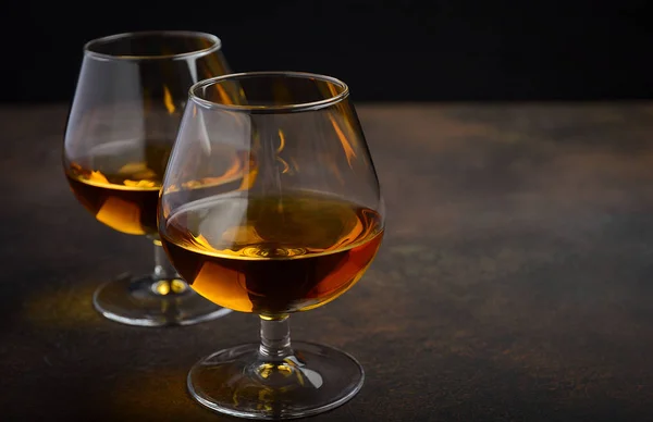 Glas av brandy eller cognac på gamla rostiga bakgrunden — Stockfoto