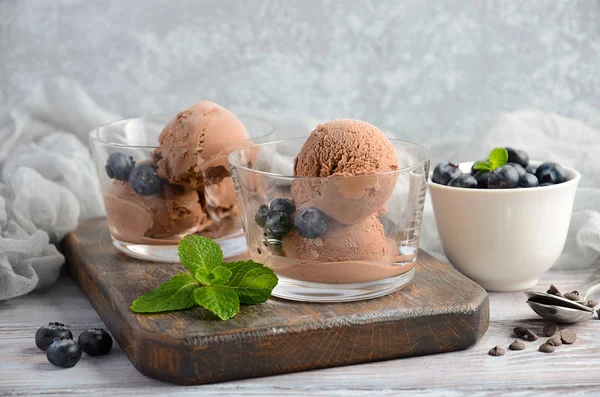 Helado de chocolate con arándanos sobre fondo rústico de madera, enfoque selectivo — Foto de Stock