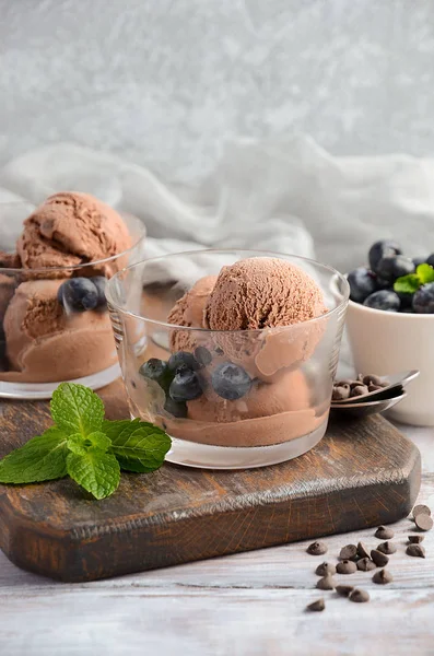 Helado de chocolate con arándanos sobre fondo rústico de madera, enfoque selectivo — Foto de Stock