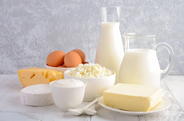 Produtos lácteos frescos. Leite, queijo, brie, Camembert, manteiga, iogurte, queijo cottage e ovos em mesa de madeira . — Fotografia de Stock