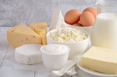 Taze süt ve süt ürünleri. Süt, peynir, brie, Camembert, tereyağı, yoğurt, peynir ve yumurta ahşap tablo.