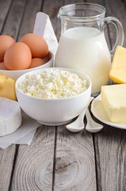 Taze süt ve süt ürünleri. Süt, peynir, brie, Camembert, tereyağı, yoğurt, peynir ve yumurta ahşap tablo.