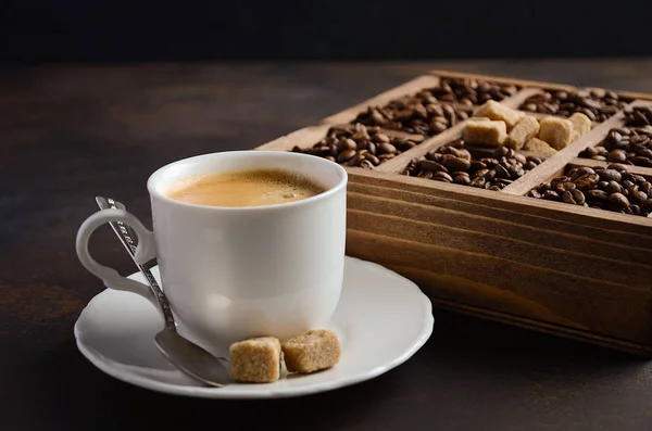 Tasse frischen Kaffee mit Kaffeebohnen auf dunklem Hintergrund — Stockfoto