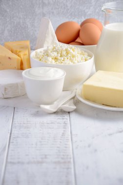 Taze süt ve süt ürünleri. Süt, peynir, brie, Camembert, tereyağı, yoğurt, peynir ve yumurta ahşap tablo.