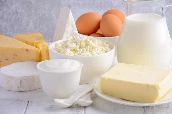 Taze süt ve süt ürünleri. Süt, peynir, brie, Camembert, tereyağı, yoğurt, peynir ve yumurta ahşap tablo. — Stok fotoğraf